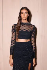 Top de encaje marrón con transparencias, mangas largas, cuello redondo y silueta ajustada al cuerpo, con diseño de espalda descubierta y lazos.