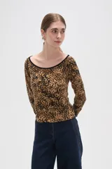 Remera de manga larga con cuello bote, confeccionada en tejido con estampado animal print tipo leopardo y borde negro en el escote.