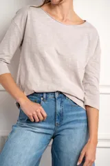 Remera oversize de algodón color blanco hueso, con cuello redondo y mangas 3/4.