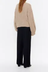 Pantalón negro de corte ancho y tiro alto, con cintura elástica fruncida y pliegues frontales.