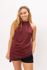 Musculosa cuello halter de corte asimétrico, color bordó, con detalle de puntilla en el ruedo.