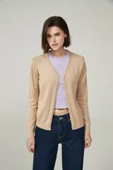 Cárdigan color beige con escote en V y cierre frontal con botones.