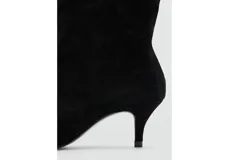 Botas de caña media en color negro, confeccionadas en piel bovina, con punta fina y taco aguja bajo.