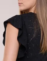 Blusa blanca de tejido calado estilo broderie con escote en V y mangas cortas tipo mariposa.