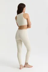 Calza larga color crema de corte alto, con cintura alta y pretina ancha.