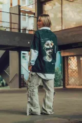 Remerón verde oscuro con efecto stone wash y estampado en la espalda de una escultura con gafas de sol y texto.