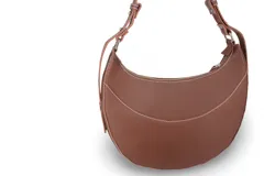 Cartera negra de cuero sintético con forma de media luna y costuras blancas.