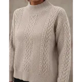 Sweater de punto color marrón con diseño de trenzas y textura en relieve. Presenta cuello alto, mangas largas y puños acanalados.