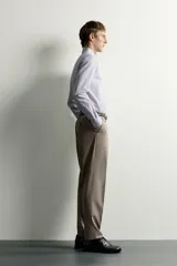 Camisa de corte slim fit con estampado de rayas verticales finas, cuello italiano, manga larga con puños abotonados y cierre frontal de botones.