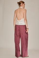 Pantalón de tiro medio color bordó con diseño de rayas verticales finas en tono claro. Presenta corte holgado, bolsillos laterales y cintura ajustable con cordón para atar.