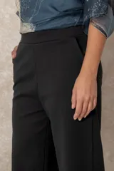 Pantalón de corte recto con bolsillos laterales, confeccionado en un tejido con acabado tipo gamuza que aporta textura y calidez.