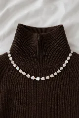 Collar corto tipo gargantilla compuesto por pequeñas flores de nácar intercaladas con cuentas doradas.