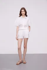 Short blanco de algodón con cintura elástica y detalles de encaje crochet en los laterales y el ruedo.