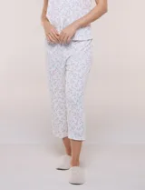Conjunto pijama de remera de manga corta y pantalón capri blanco con delicado estampado floral en tonos rosados y verdes, confeccionado en tejido acanalado fino con escote redondo y detalle de gota con botón.