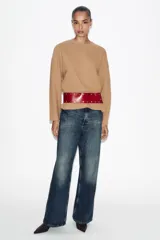 Cinturón tipo fajín ancho confeccionado en piel 100% color bordó, con detalle de tachas metálicas plateadas a contraste y cierre frontal con botones a presión.