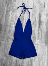 Mono corto de color rojo, con escote halter y espalda descubierta.