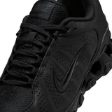 Championes Nike modelo Reax 8 SL, de color negro, con tecnología de amortiguación en el talón, perforaciones laterales para mayor transpirabilidad y diseño deportivo.