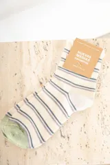 Medias color crudo con rayas horizontales en azul y lila, talón y puntera en verde.