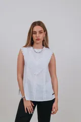 Musculosa blanca sin mangas con detalles de bordado inglés y apliques en el pecho.