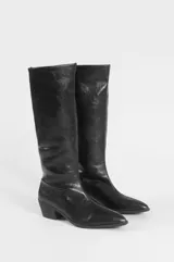Botas bucaneras de caña alta, color negro, con acabado brillante, punta fina y taco cuadrado bajo.