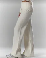 Conjunto de dos piezas de punto acanalado en color crema, compuesto por un sweater envolvente con escote en V y detalles de encaje en los bordes, y un pantalón de tiro alto con cintura elástica ancha y detalle de encaje en el ruedo.