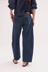 Pantalón jean de algodón con corte barrel y tiro bajo, de color azul, con bolsillos delanteros y traseros.