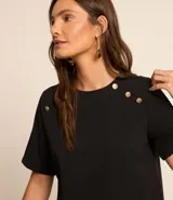 Blusa negra de crepé con cuello redondo, mangas cortas y botones dorados decorativos en los hombros.