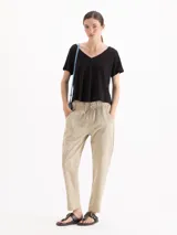 Pantalón de gabardina color bordó, de tiro medio con cintura elastizada y cordón regulable. Presenta calce relajado, corte recto y largo hasta los tobillos, con bolsillos laterales.