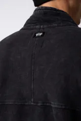 Buzo de frisa con efecto de lavado snow, corte oversize, cuello alto con medio cierre frontal y bordado al tono en el pecho. Cuenta con bolsillos laterales.