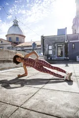 Calza larga de lycra color bordó con estampado de figuras geométricas en tonos rosados.