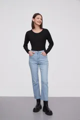 Pantalon jean de corte flare, tiro medio, con ruedo desflecado y cierre frontal con botón y cremallera.