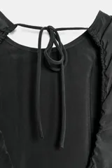 Vestido midi de corte fluido, cuello redondo y diseño sin mangas. Presenta una abertura en la espalda con cierre de lazada ajustable.