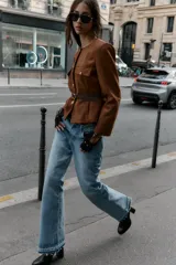 Blazer de cuello redondo y manga larga, confeccionado en tejido efecto ante. Presenta cierre frontal con botones, bolsillos con tapeta en el pecho y cinturón ajustable en la cintura.