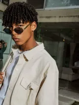 Camisa de manga corta color crudo, confeccionada en gabardina, con cuello camisero y botones frontales. Presenta un bolsillo de parche en el pecho y bordado en la espalda.