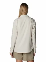 Camisa de senderismo Columbia de manga larga, color beige, con cuello clásico, cierre frontal con botones y bolsillos funcionales en el pecho. Cuenta con ventilaciones traseras de malla para mayor transpirabilidad y tecnología de protección solar y absorción de humedad.