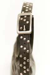 Cartera negra de cuero con forma de medialuna y tachas en zigzag.