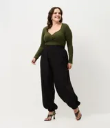 Pantalón de corte aladín confeccionado en crepé, de tiro alto con cintura elástica en la parte trasera. Presenta piernas anchas con volumen tipo globo que se estrechan en los tobillos mediante puños elásticos. Incluye bolsillos laterales funcionales.