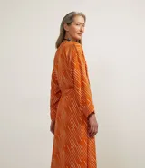Kimono largo color naranja con estampado de rayas blancas diagonales, mangas largas y lazo para atar en la cintura.