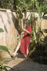 Vestido tejido artesanal a rayas horizontales en tonos marrón y rojo, con cuello redondo y mangas cortas.