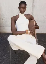 Top de punto fino sin mangas con cuello halter y diseño entallado al cuerpo.