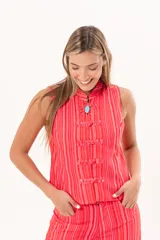 Chaleco de inspiración oriental, color rojo a rayas, con cuello alto, sin mangas y cierre frontal con nudos de presilla.
