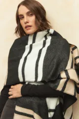 Poncho con diseño a rayas en tonos negro, blanco y beige.