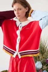 Cardigan de punto con diseño tricolor, de corte relajado, manga larga de tejido trenzado en contraste de color, cuello solapa tipo polo y cierre frontal de botones.