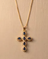 Collar con dije de cruz de bronce con baño de oro y piedras ovaladas color azul.