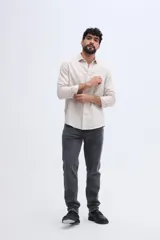 Camisa de lino de manga larga en color beige, con cuello camisero clásico y cierre frontal de botones.
