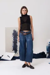 Jean de tiro medio con corte amplio y recto, confeccionado en denim azul con lavado clásico. Presenta cierre frontal con botón metálico y bolsillos funcionales.