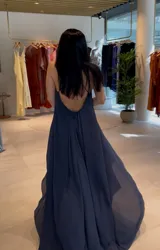 Vestido largo amarillo con breteles finos y escote en V. Tiene corte imperio y falda con caída fluida.