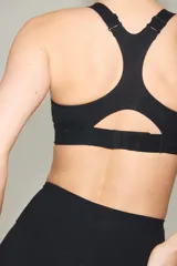 Top deportivo negro con tecnología ShapeMove y DryMove, de alto soporte, con copas forradas con relleno extraíble, breteles anchos ajustables y espalda nadadora de corte olímpico.
