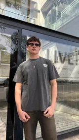 Remera negra con estampa en la espalda con la frase "NEOVISION" y otros textos en blanco. Corte oversized.