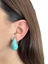 Aros colgantes con forma de lágrima, color celeste tornasolado con acabado perlado.